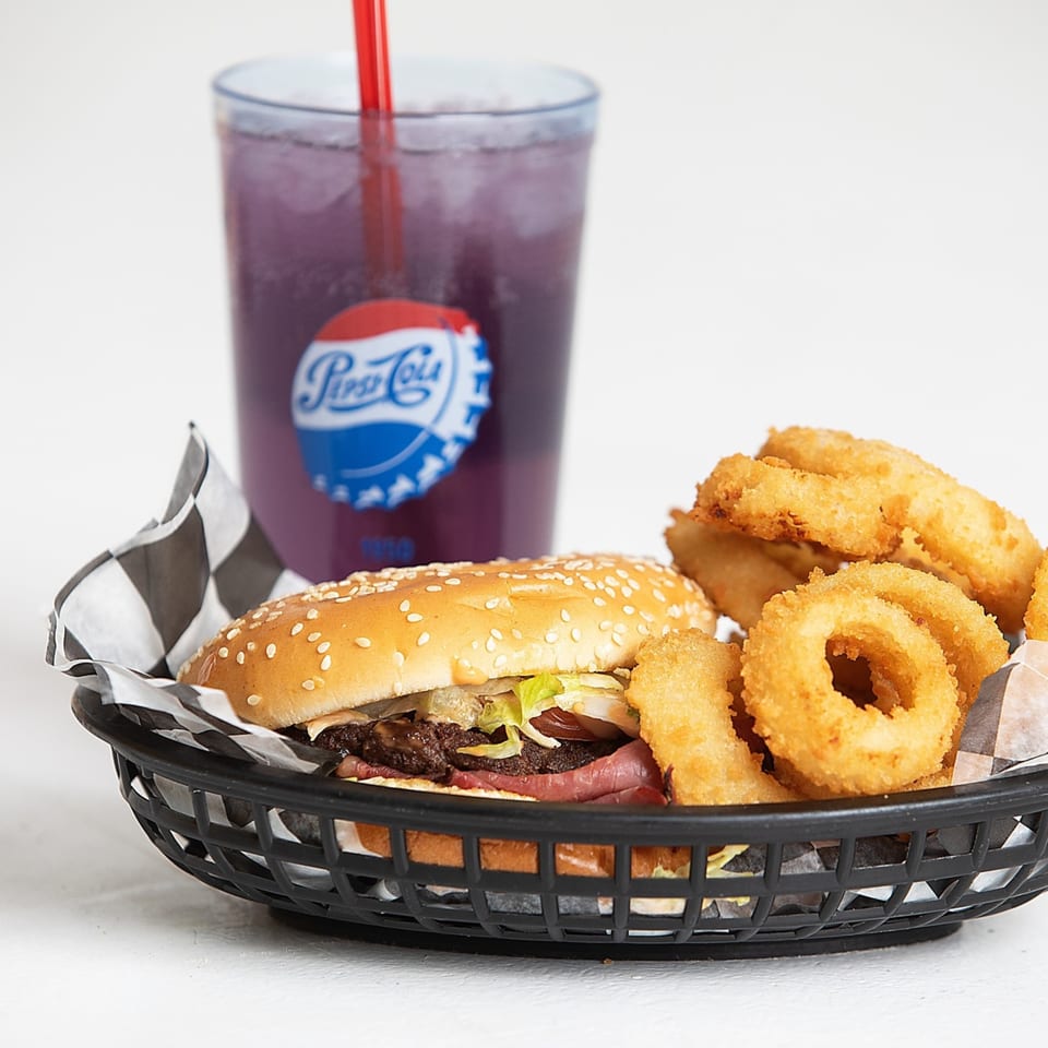 Kirt's Drive-In burger and onion rings in a basket, with a purple Pepsi-Cola drink.